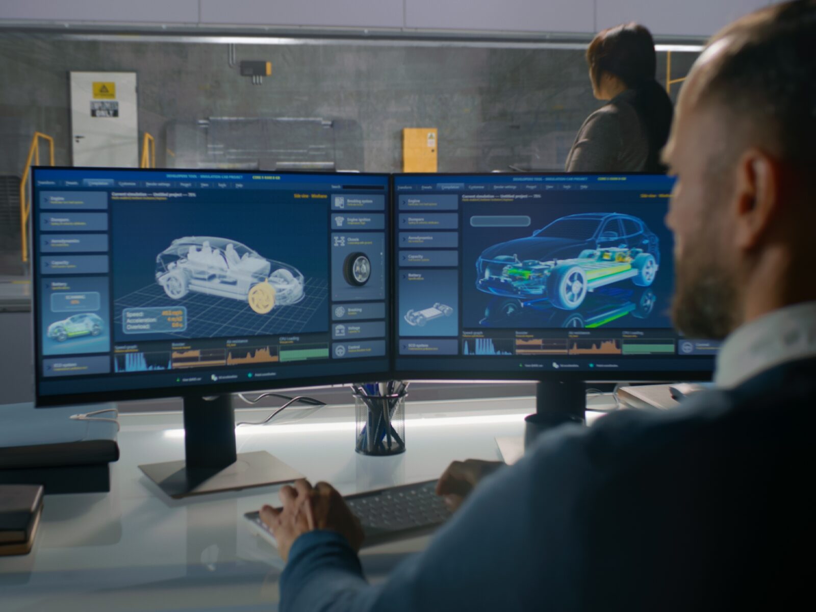 Engineer with a dual monitor display of automotive animations