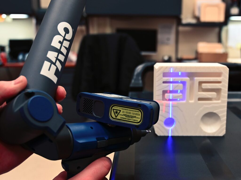 Lab technician uses a FARO laser scanner arm on a 3D block