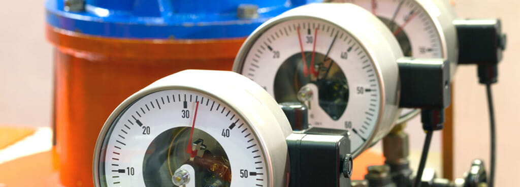 Two dial barometers display two separate readings, needing barometer calibration services.