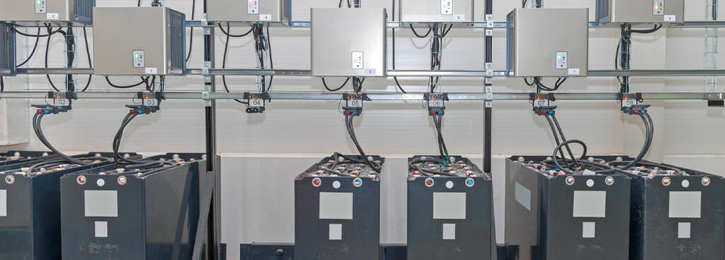 A row of industrial equipment chargers made with heavy-duty storage batteries.