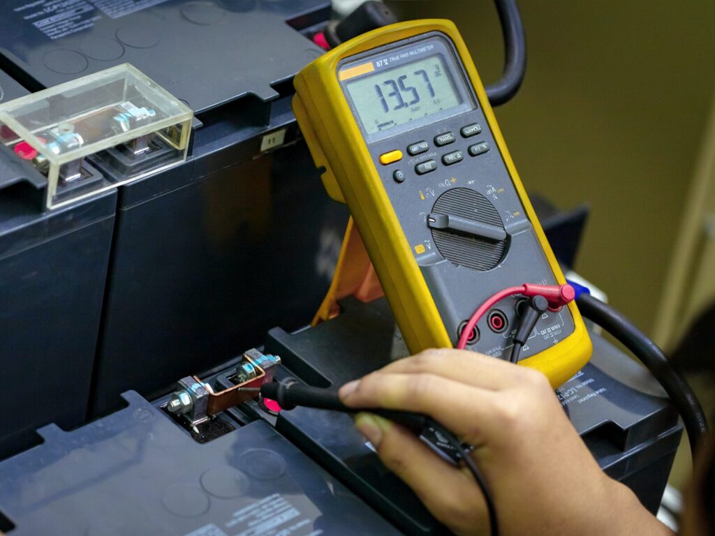 Yellow Fluke multimeter attached to a large battery pack