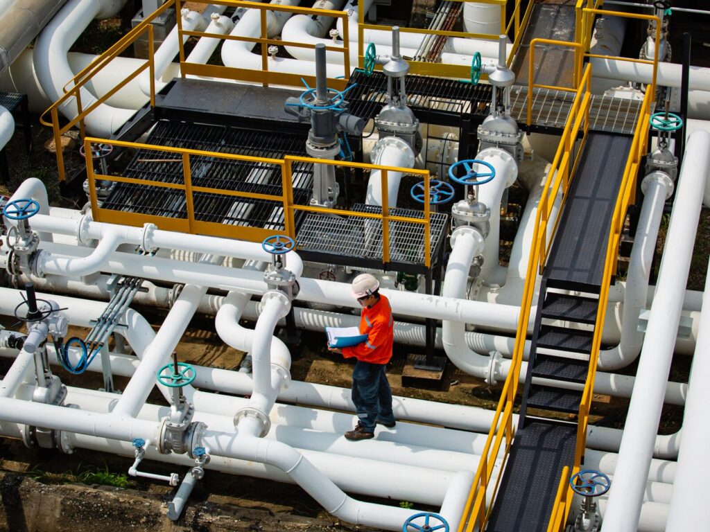 Field technician observes a gas flow meter at an oil refinery.