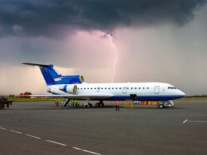 Commercial Aircraft with Lightning Striking Behind It