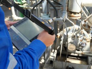 Technician performs vibration analysis on a motor at an oil pipeline