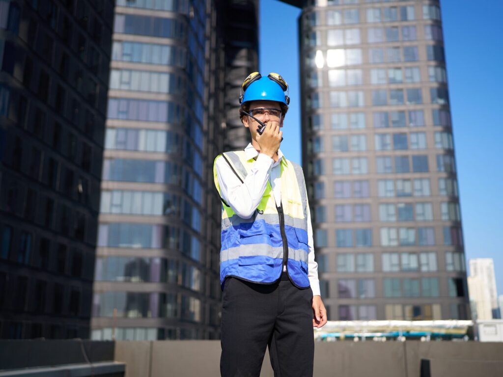 Expert roof consult on a commercial building roof. Skyscrapers in the background.