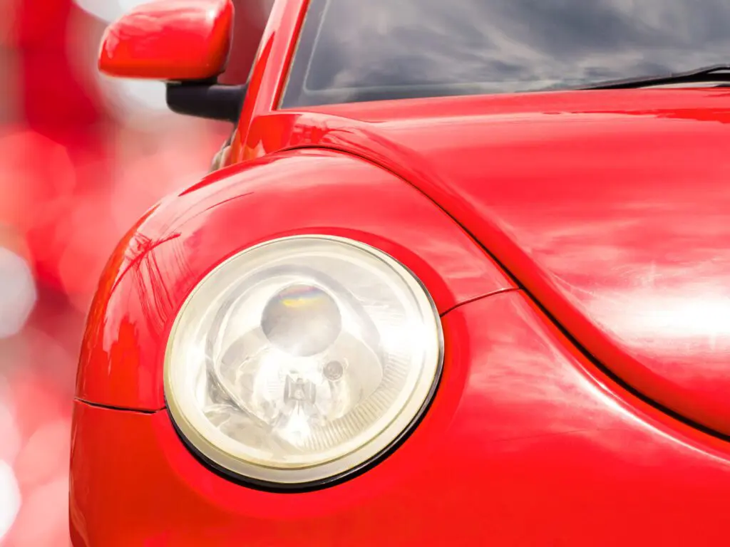 Close up on the headlight of a red vehicle