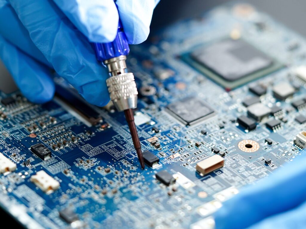 Technician repairs a circuit board with a soldering iron