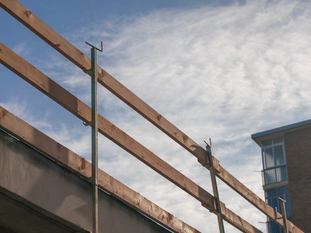 Fall arrest scaffolding attached to a roof parapet