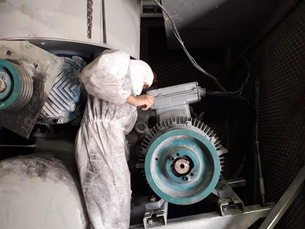 Reliability technician dressed in protective clothing inspects a blower wheel