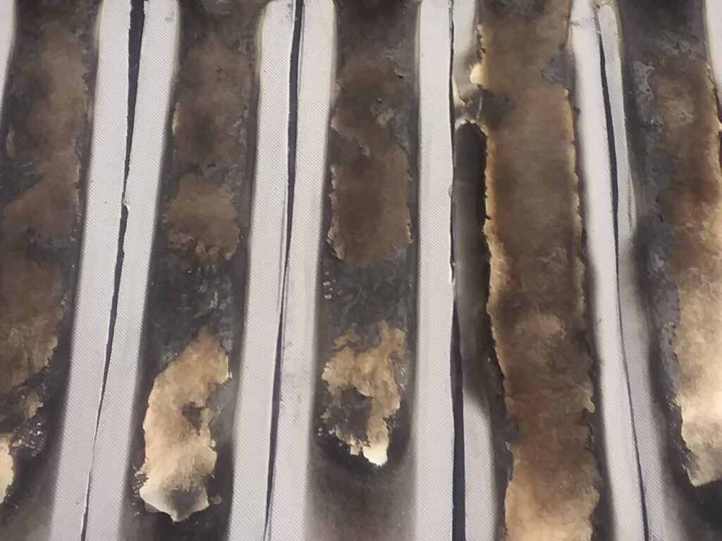 Strips of burned plastic after flammability testing