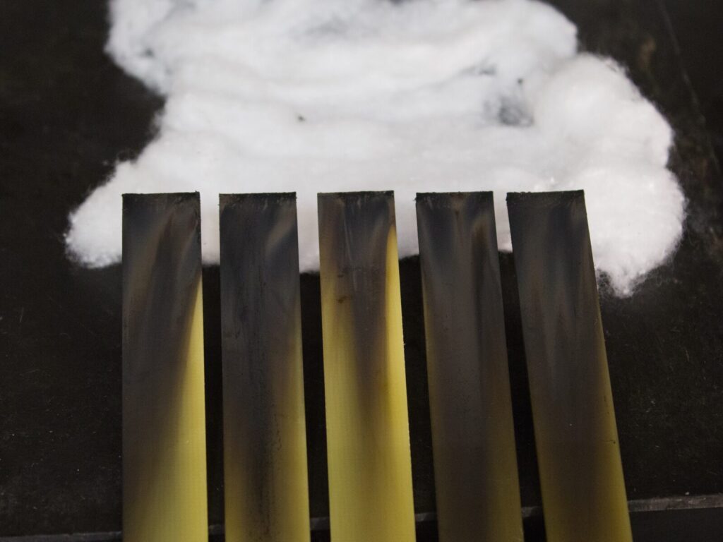 Five plastic samples and smoke during flammability testing