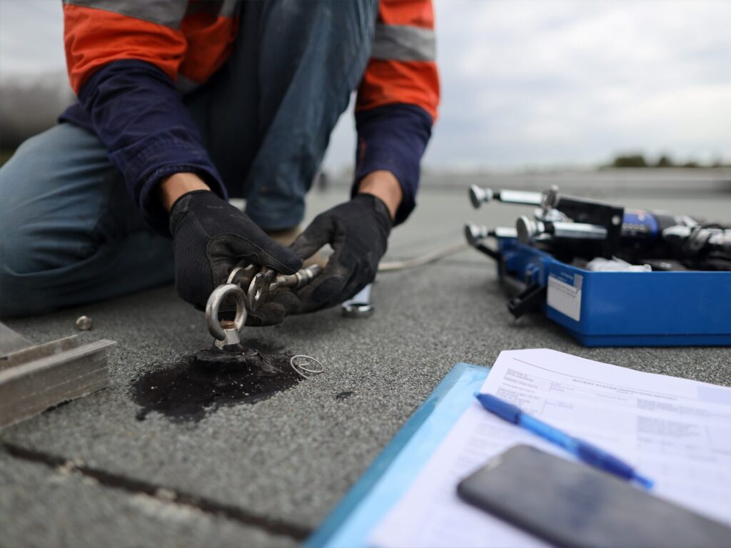 Engineer inspects a roof tie back anchor.