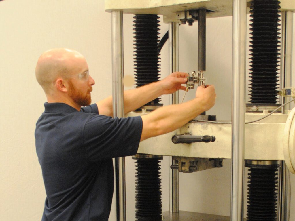 Engineer positions a specimen for tensile testing in our mechanical testing lab.