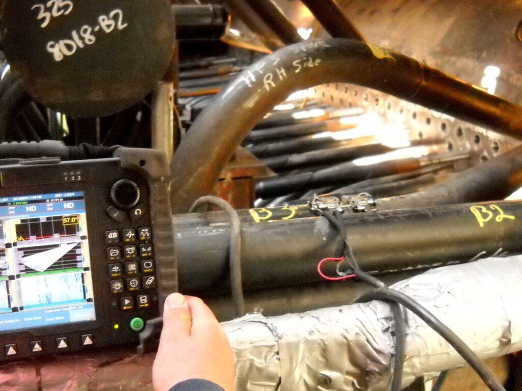 Technician performs phased array test on high pressure piping