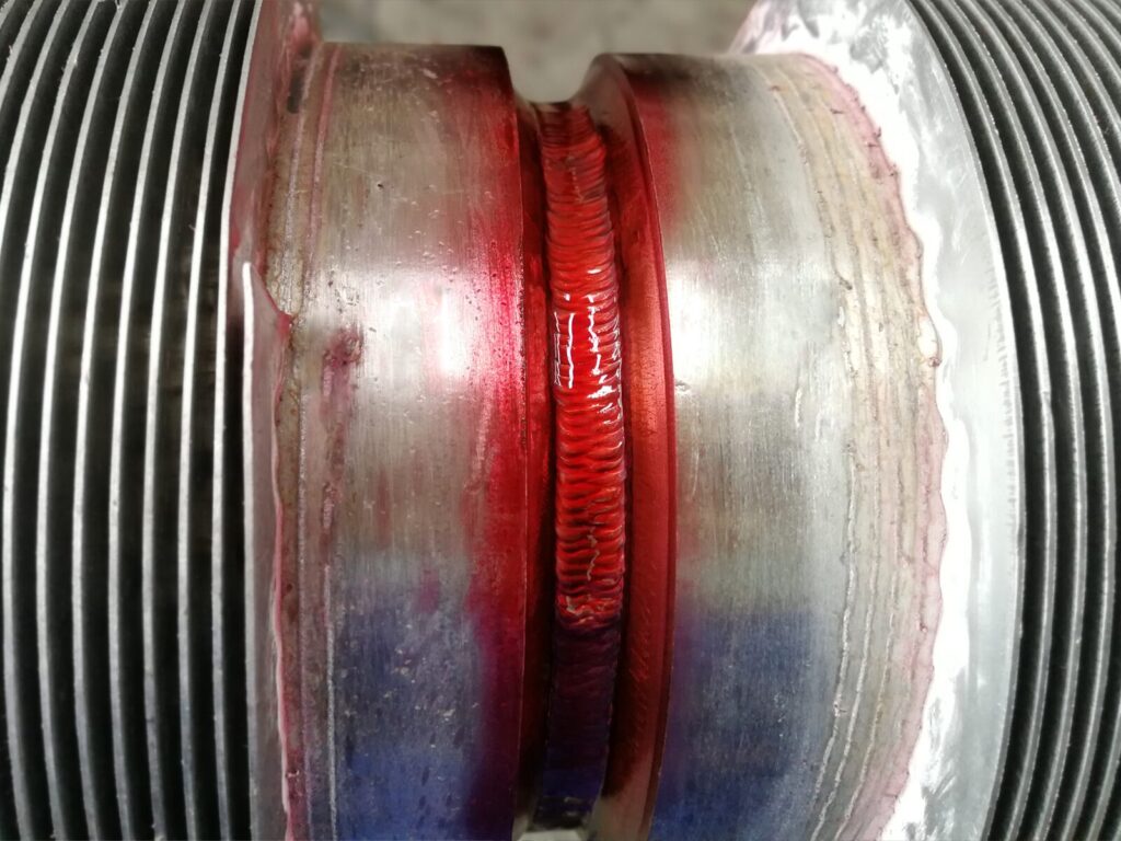 Two welded pipes during liquid penetrant testing