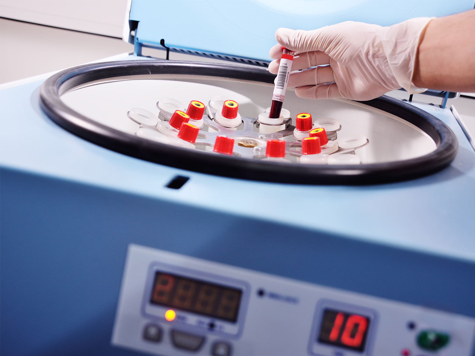 Chemist places a sample in a centrifuge