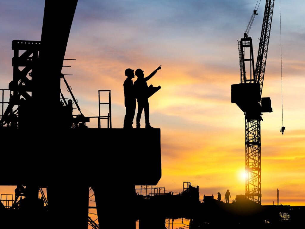 Engineers on a construction site at sunset.