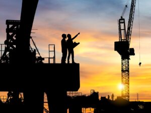 Engineers on a construction site at sunset.