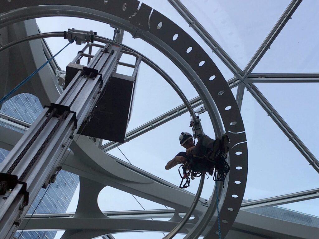 A rope access technician in a spherical industrial structure