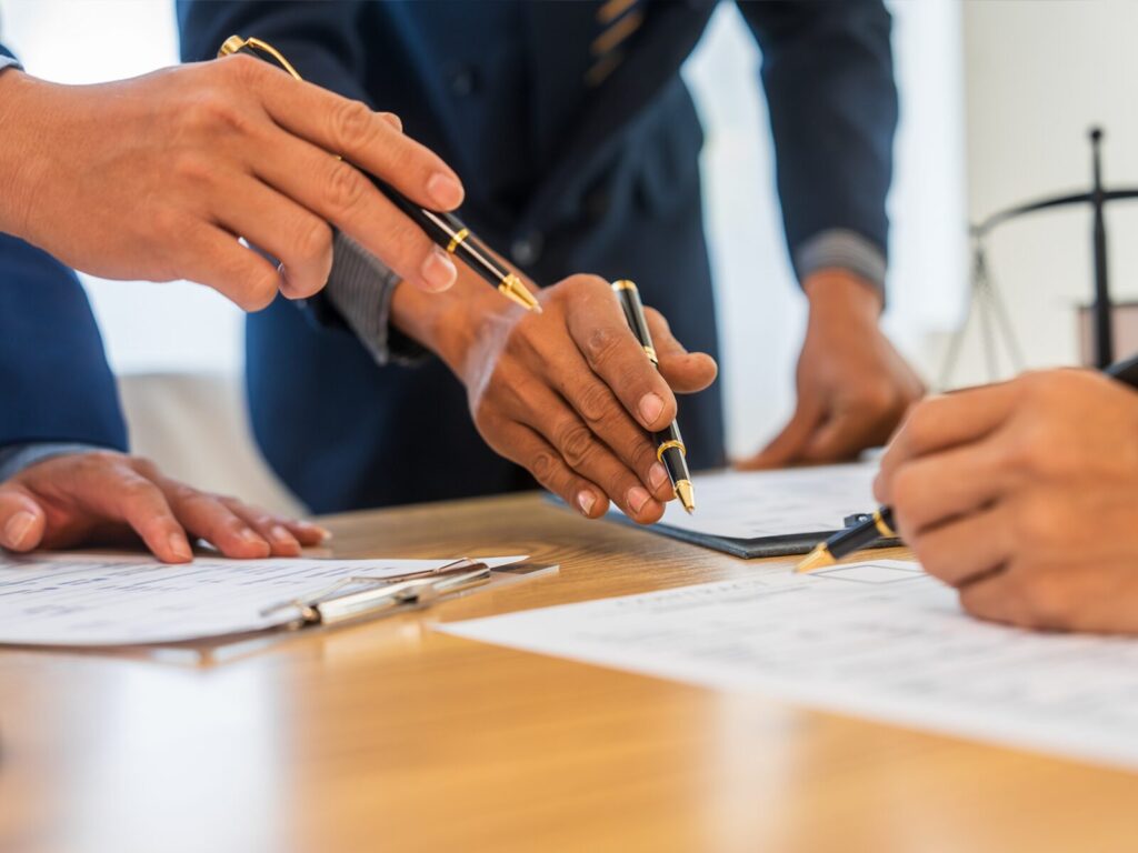 Three legal and forensic experts collaborate over paperwork