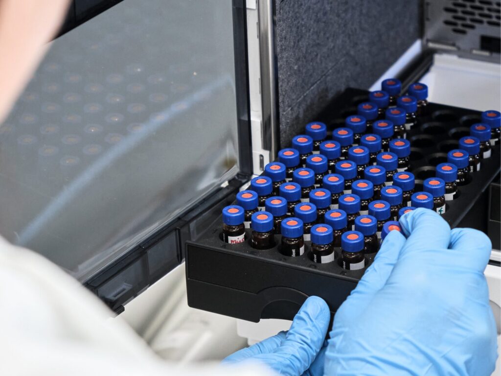 Chemist loads samples into a high pressure liquid chromatography chamber