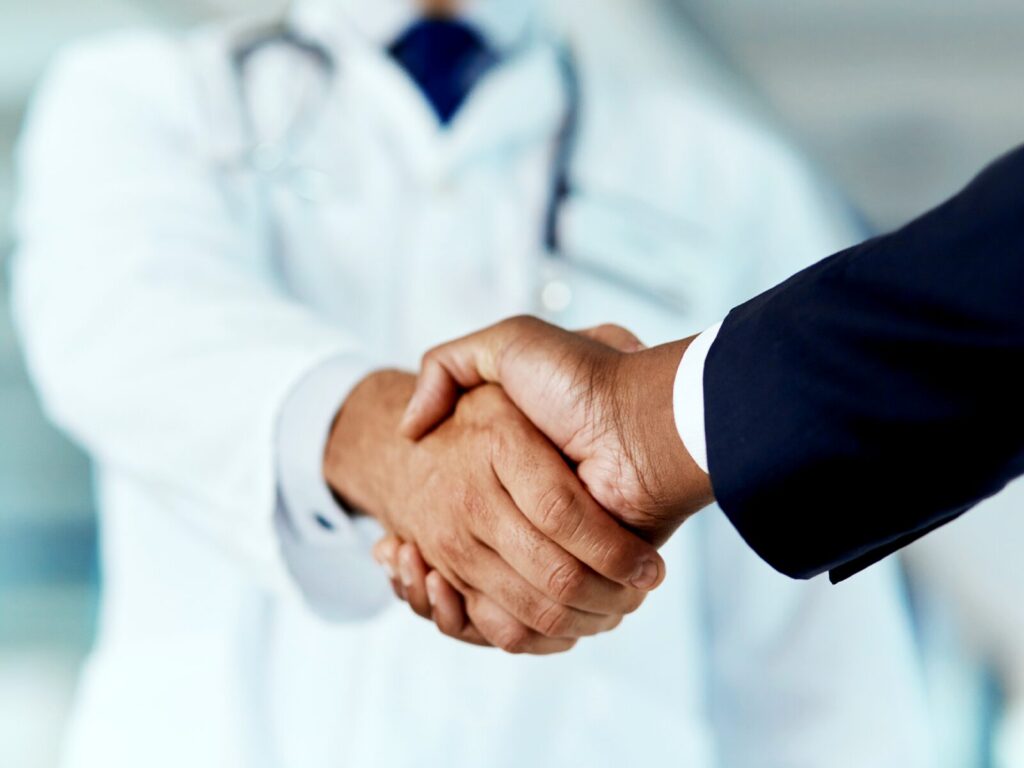 Doctor and businessman shake hands