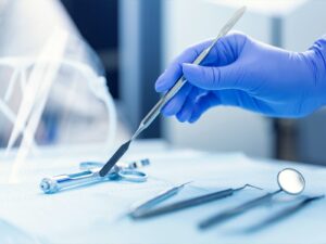 Gloved hand holding surgical tool