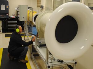 Technician adjusts a large wind tunnel anemometer