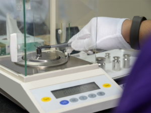 Technician loads a weight standard on a digital scale