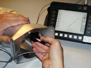 Technician performs Eddy Current testing on an airplane component