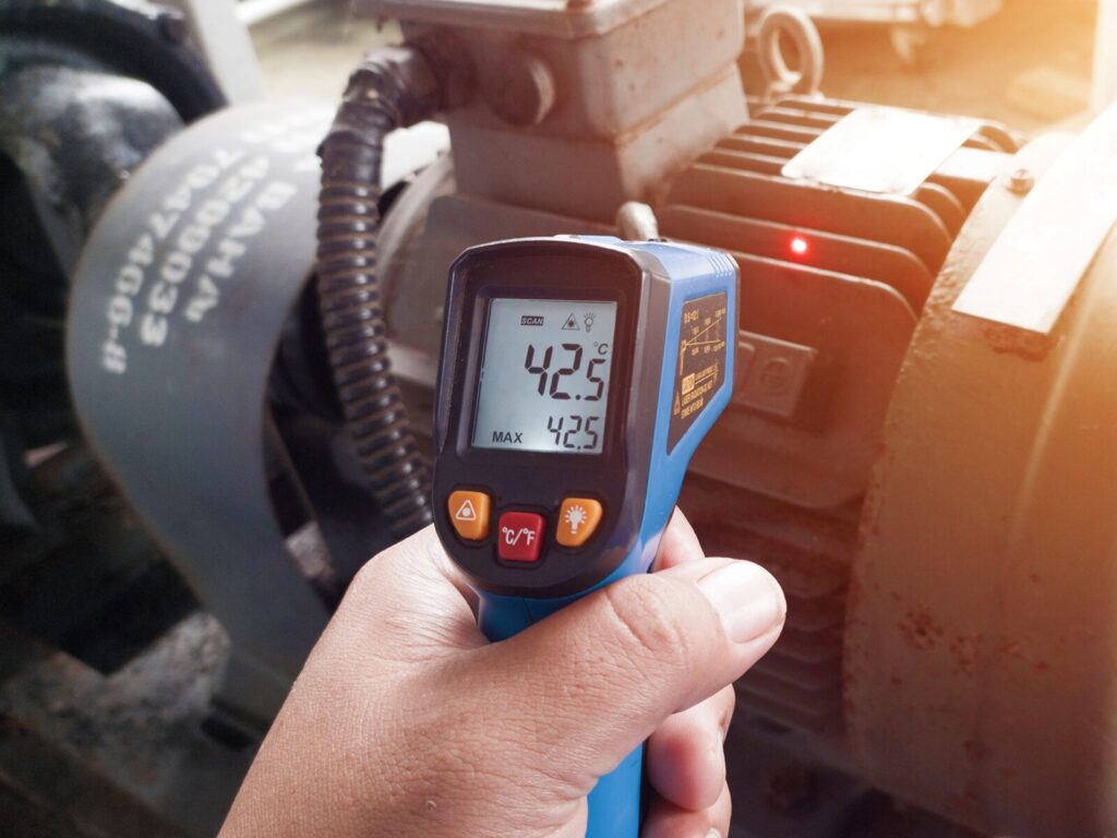 Infrared thermometer scans an electric motor for high temperatures.