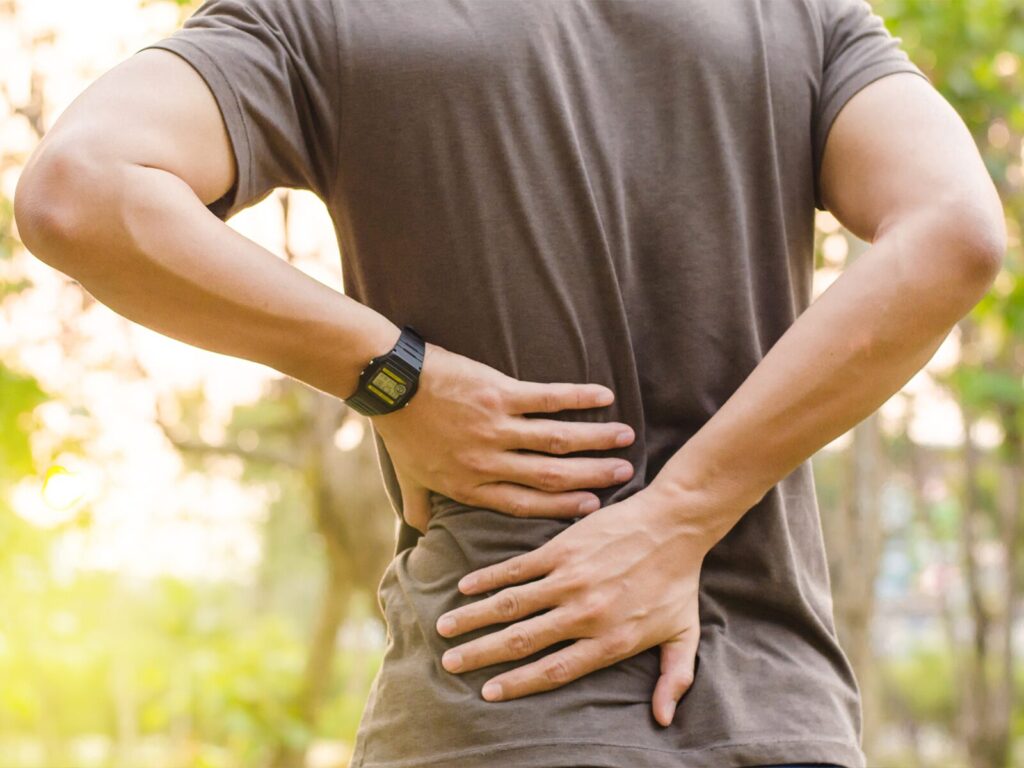 Man grips his lower back