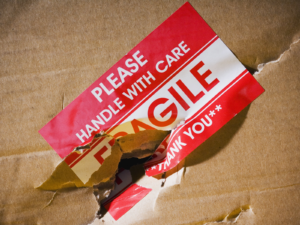 Damaged package with a hole in the fragile sticker