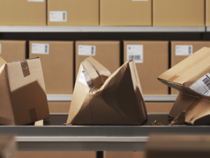 Conveyor belt with crushed packages in a warehouse