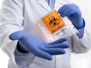 Medical practitioner holds a biohazard waste bag