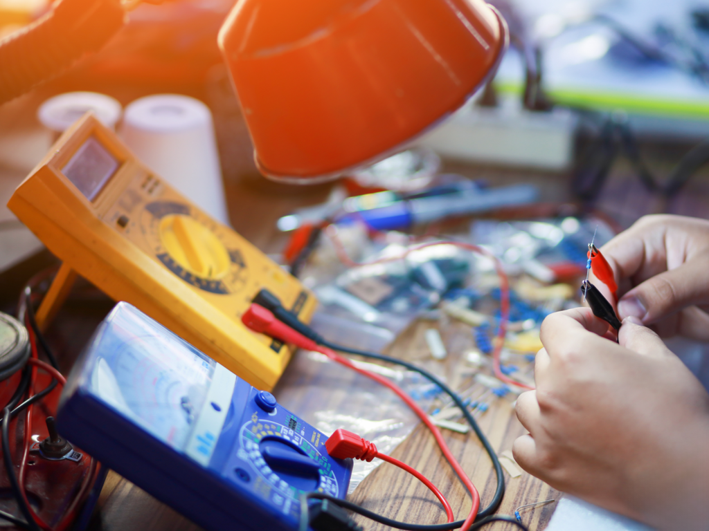 Technician holds the clamps for a voltmeter and multimeter