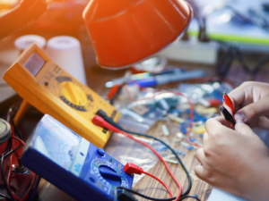 Technician holds the clamps for a voltmeter and multimeter