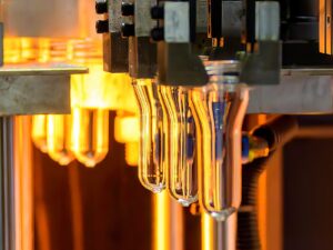 A belt of plastic tubes emerges from a blowing machine