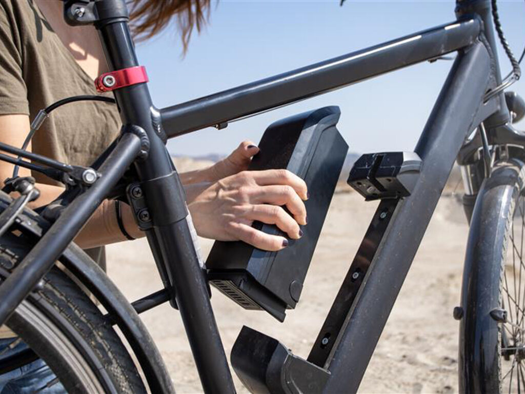 Person Installing Battery into E-Bike