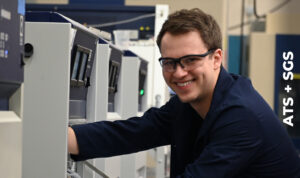 A technician loads a sample into a chamber for exposure to ultraviolet rays